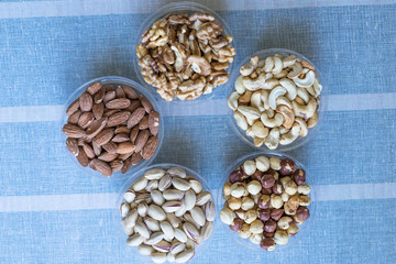 Fototapeta na wymiar Healthy food. Nuts mix assortment on stone texture top view. Collection of different legumes for background image close up nuts, pistachios, almond, cashew nuts, peanut, walnut. image