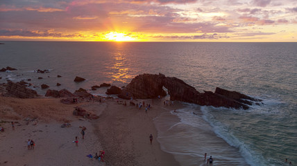 Aerial view of sunset on the beach with rocks