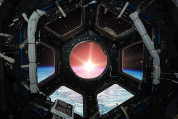 Fascinating sunrise on earth. Spaceship window view. Elements of this image furnished by NASA.