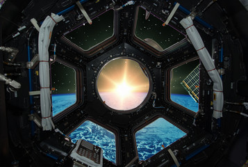 Fascinating sunrise on earth. Spaceship window view. Elements of this image furnished by NASA.