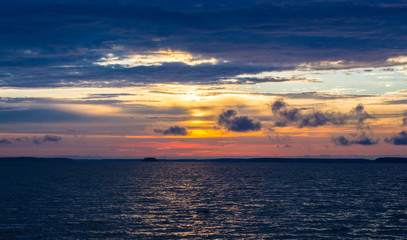 bright colorful sunset with yellow orange pink blue colors and clouds on the sky above big river Volga in Russia 