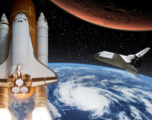 Rocket flies from earth to Mars. Shuttle in the distance. The elements of this image furnished by...