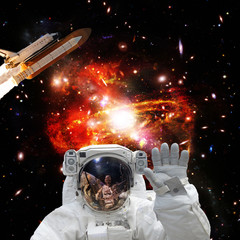 Astronaut posing. Rocket on the backdrop. The elements of this image furnished by NASA.