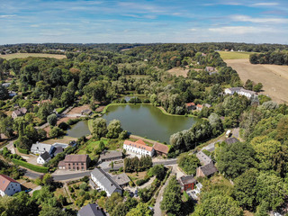Aerial view of country side area in Walloon Brabant, Belgium. Luxury villas with garden surrounded by forest and small lake during autumn season - obrazy, fototapety, plakaty