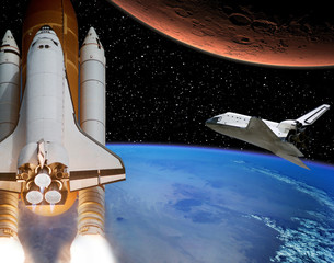 Rocket flies from earth to Mars. Shuttle in the distance. The elements of this image furnished by...