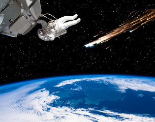 Astronaut holding for the spaceship and meteor rain. The elements of this image furnished by NASA.