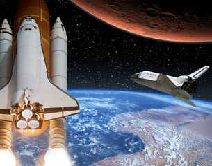 Naklejka premium Rocket flies from earth to Mars. Shuttle in the distance. The elements of this image furnished by NASA.