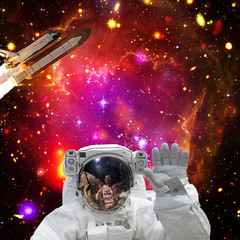 Astronaut posing. Rocket on the backdrop. The elements of this image furnished by NASA.