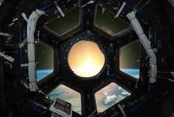 Fascinating sunrise on earth. Spaceship window view. Elements of this image furnished by NASA.