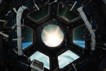 Fascinating sunrise on earth. Spaceship window view. Elements of this image furnished by NASA.