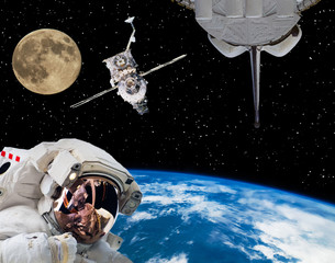 Fototapeta premium Astronaut in outer space, moon and spaceships on the backdrop. The elements of this image furnished by NASA.