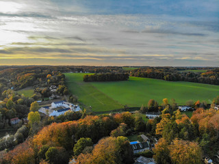 Fototapeta na wymiar Aerial view of country side area in Walloon, Belgium, Luxury villas & farm surrounded by forest and farmland during beautiful sunset color.