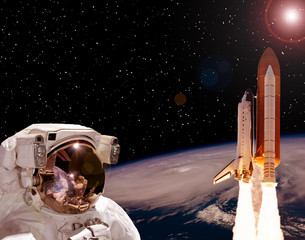 Astronaut staring on the rocket that flying from earth. The elements of this image furnished by...