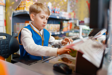 Boy in uniform at the register playing salesman