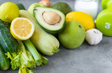 green vegetables on grey background, avocado, cucumber, zucchini, celery, lemon , Apple ,garlic