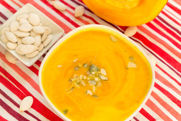 2 plates of pumpkin soup on a striped towel