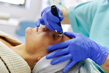 Skin care. Woman receiving facial beauty treatment. Facial therapy. Anti-aging procedures.
