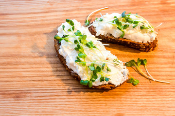 Rye bread with curd radish on a brown wooden board