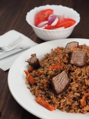 Rice with Vegetables and Meat in a plate on wooden table