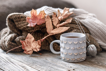 Cozy autumn morning breakfast in bed still life scene. Steaming cup of hot coffee, tea standing near window. Fall.
