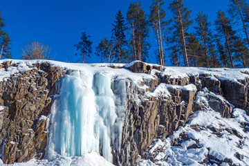Karelia. Russia. Frozen waterfall in the canyon. Karelian waterfalls. Snow-covered rocks. Ruskeala. Northern nature of Karelia. Winter Karelia. Travelling to Russia. - obrazy, fototapety, plakaty