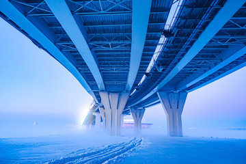 Modern bridge construction. Highway on stilts. speedway along the frozen coast. Winter expressway. City road junction. Road infrastructure. Bridge viaduct. Road routes of communication.