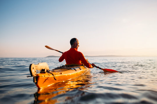 Rear View Of Senior Man Enjoy Paddling Kayak 