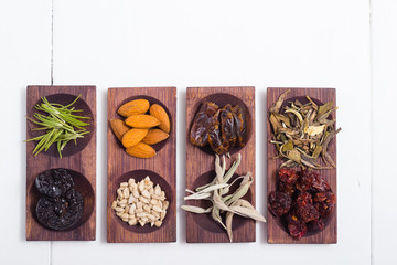 dried fruits and spices on wooden tray, white table
