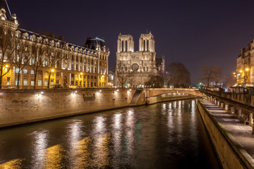 Fototapeta premium Notre Dame Cathedral and the Seine river in Paris at night, France.