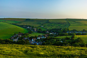 Fototapeta na wymiar An aerial view of a rural village at sunset with majestic blue sky