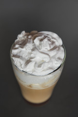 large transparent glass filled with cold summer drink coffee with milk photographed on the isolated gray background picture for the menu.