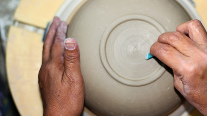 hands of a potter, creating an bowl on the circle, Pottery polishing process with 2 hands in the final step. Before entering the kiln.