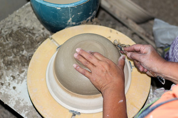 hands of a potter, creating an bowl on the circle, Pottery polishing process with 2 hands in the final step. Before entering the kiln.
