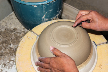 hands of a potter, creating an bowl on the circle, Pottery polishing process with 2 hands in the final step. Before entering the kiln.