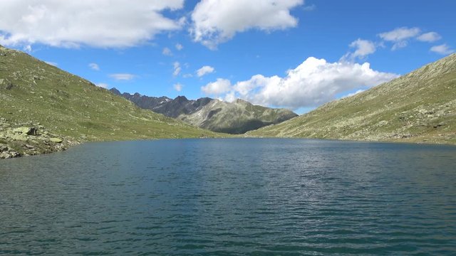 Scenic view of peak of mountains and lake in Swiss Alps. Summer landscape, sunshine weather, blue sky and sunny day