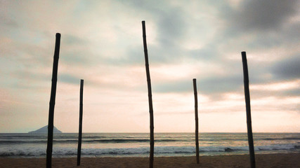 Fototapeta premium Sunset on beach with bamboos support