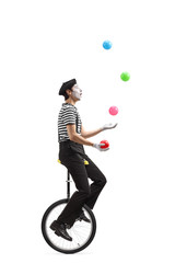Mime on a unicycle juggling with balls