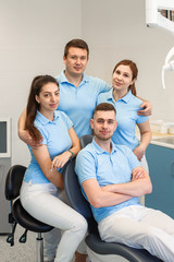 Fototapeta premium Group of young and happy dental doctors stand near each other at dental clinic. Teamwork and business concept.