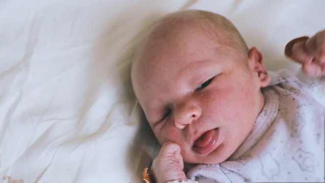 Beautiful newborn baby boy, laying in crib in prenatal hospital