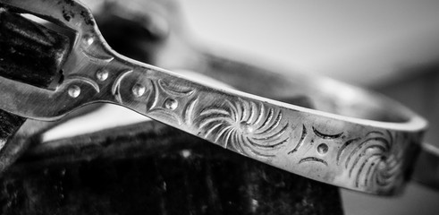 Close up of Silver stirrup with engraved detail in black and white - obrazy, fototapety, plakaty