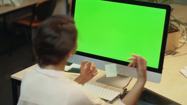 Young woman call video online on computer with green screen in office