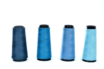 Colorful sewing thread reels on white background