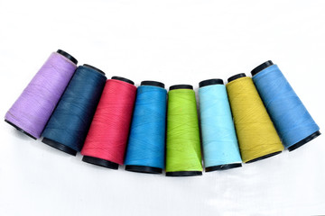 Colorful sewing thread reels on white background