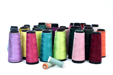 Colorful sewing thread reels on white background