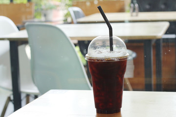 Black coffee with ice on table in cafe.