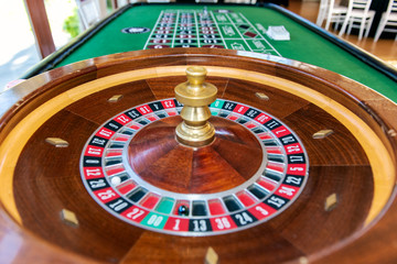 Roulette table wheel and long table with markings for players to place their wagers and hopes to gamble a win.