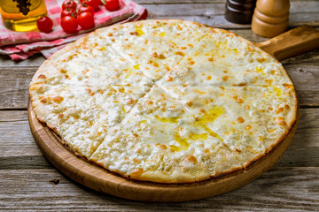 Pizza Quattro formaggi on wooden background