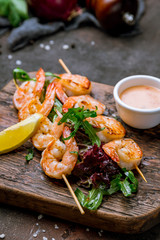 tiger shrimp kebab on the board on dark concrete rustic background
