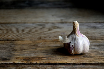 A whole head of garlic on the background of old boards.