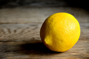 A whole lemon on a wooden rustic table.